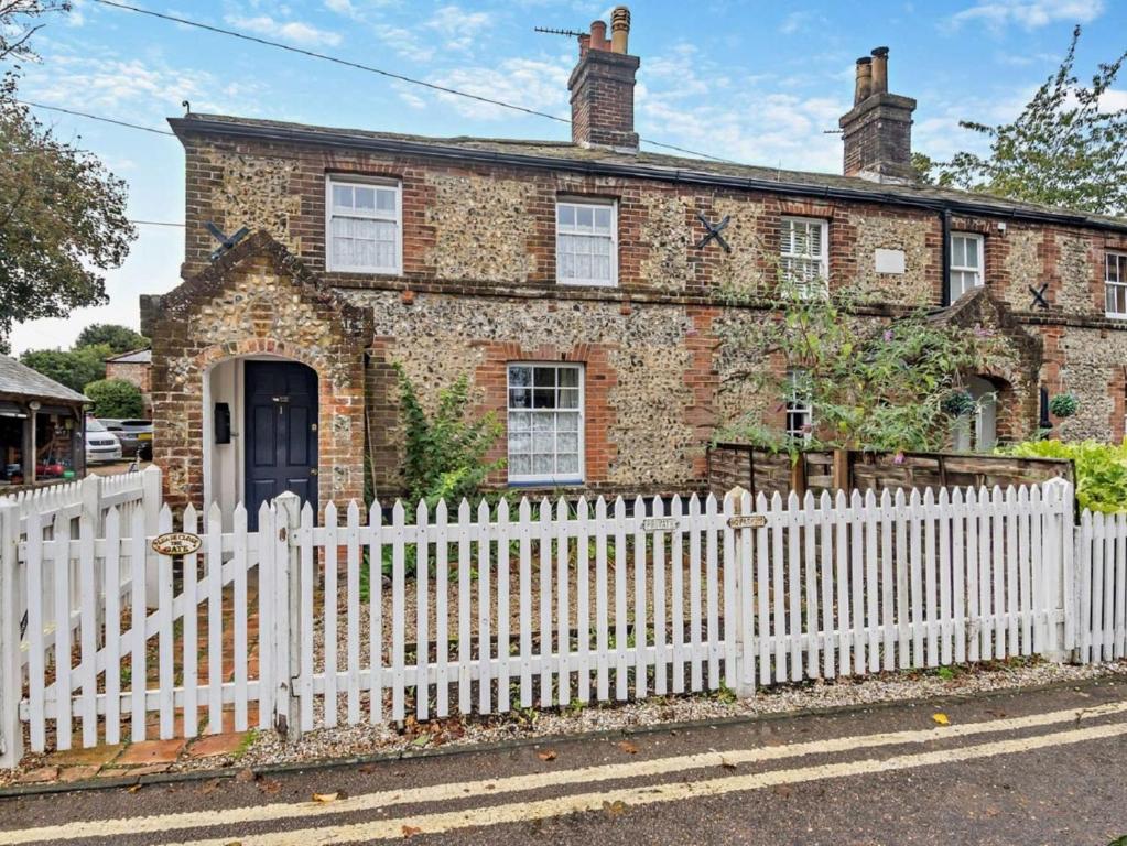 a white picket fence in front of a brick house at 1 Bed in Wymondham oc-43278 in Wymondham