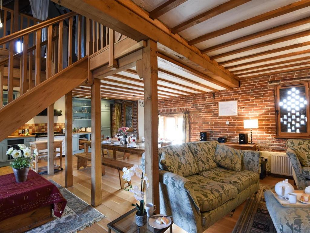 a living room with a couch and a brick wall at 3 Bed in Briston oc-kt187 in Briston