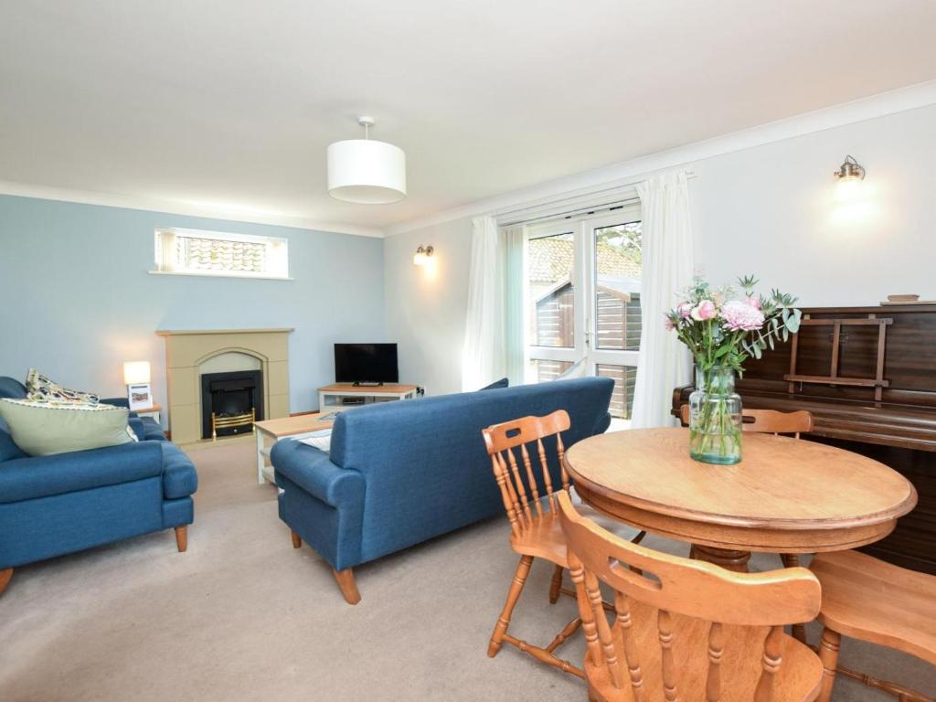 a living room with a blue couch and a table at 2 Bed in Dereham oc-57133 in Mattishall