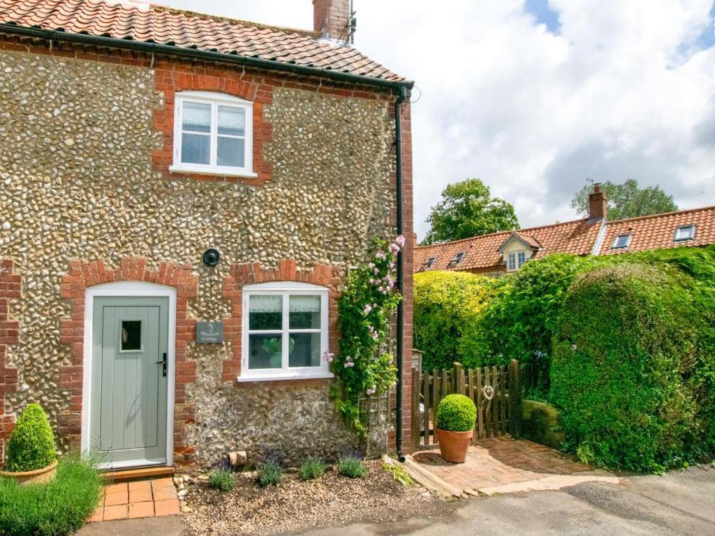 a brick house with a white door and a fence at 2 Bed in Syderstone oc-kt197 in Syderstone