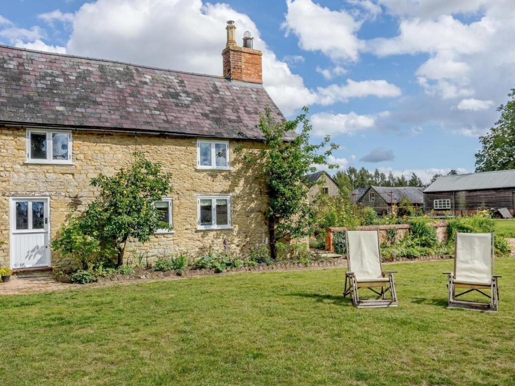 two chairs in front of a stone house at 1 Bed in Bedford oc-79095 in Turvey