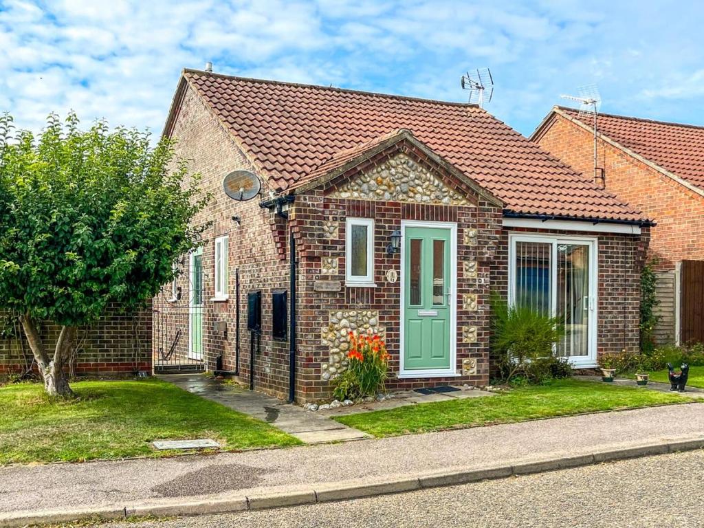 a brick house with a green door on a street at 2 Bed in Norwich oc-75398 in Mundesley