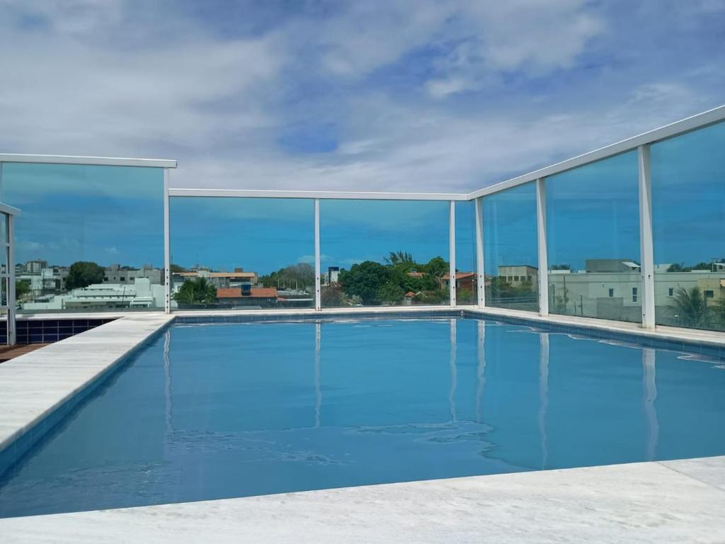 a swimming pool with a view of a building at Apartmento em Carapibus in Conde