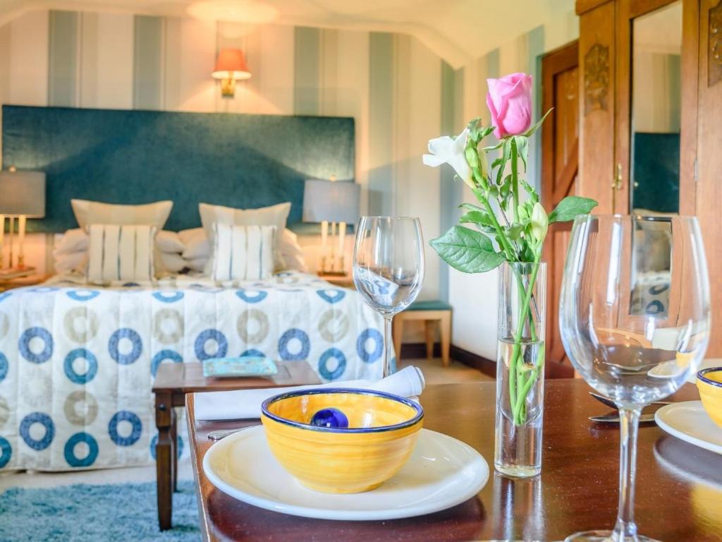 a room with a bed and a table with wine glasses at 1 Bed in Bedford oc-78984 in Wyboston