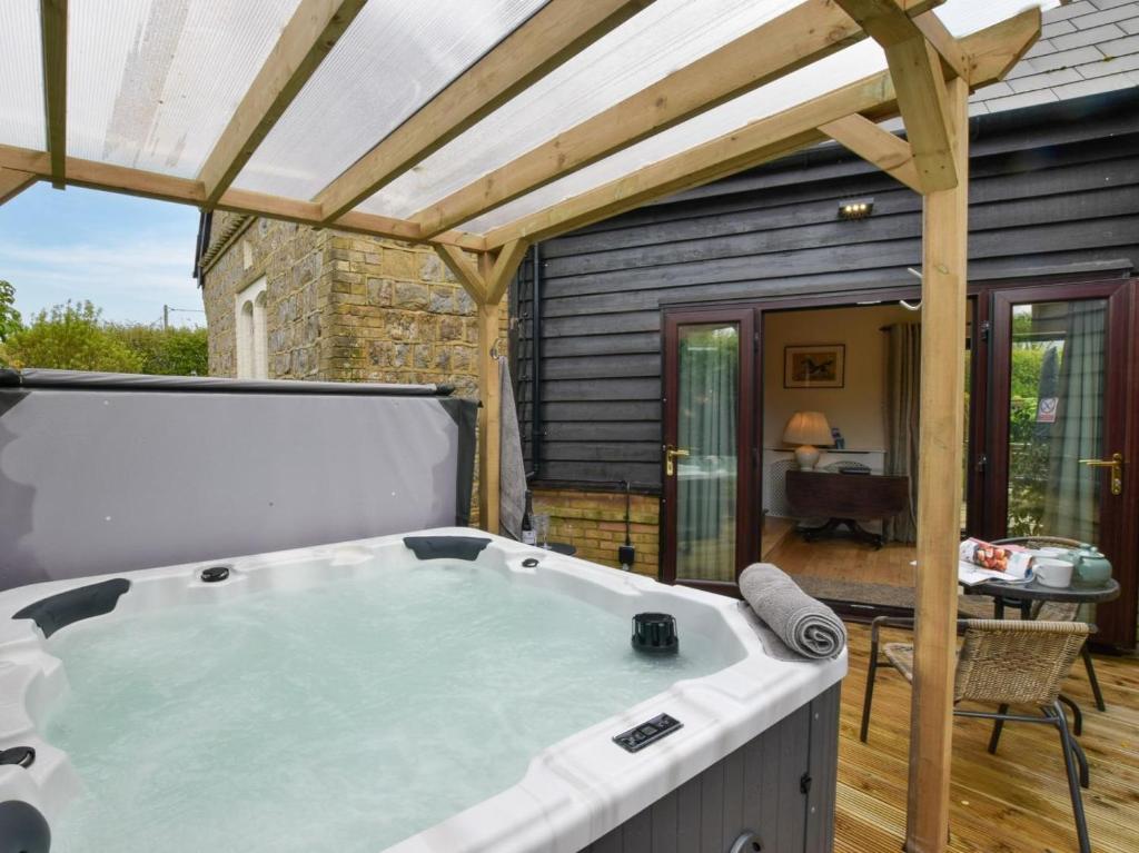 a hot tub on the deck of a house at 4 Bed in Ashford oc-86647 in Ashford