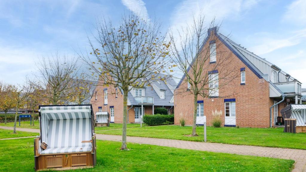 a chair sitting in the grass in front of a house at Hapimag Resort Dünenblick in Westerland