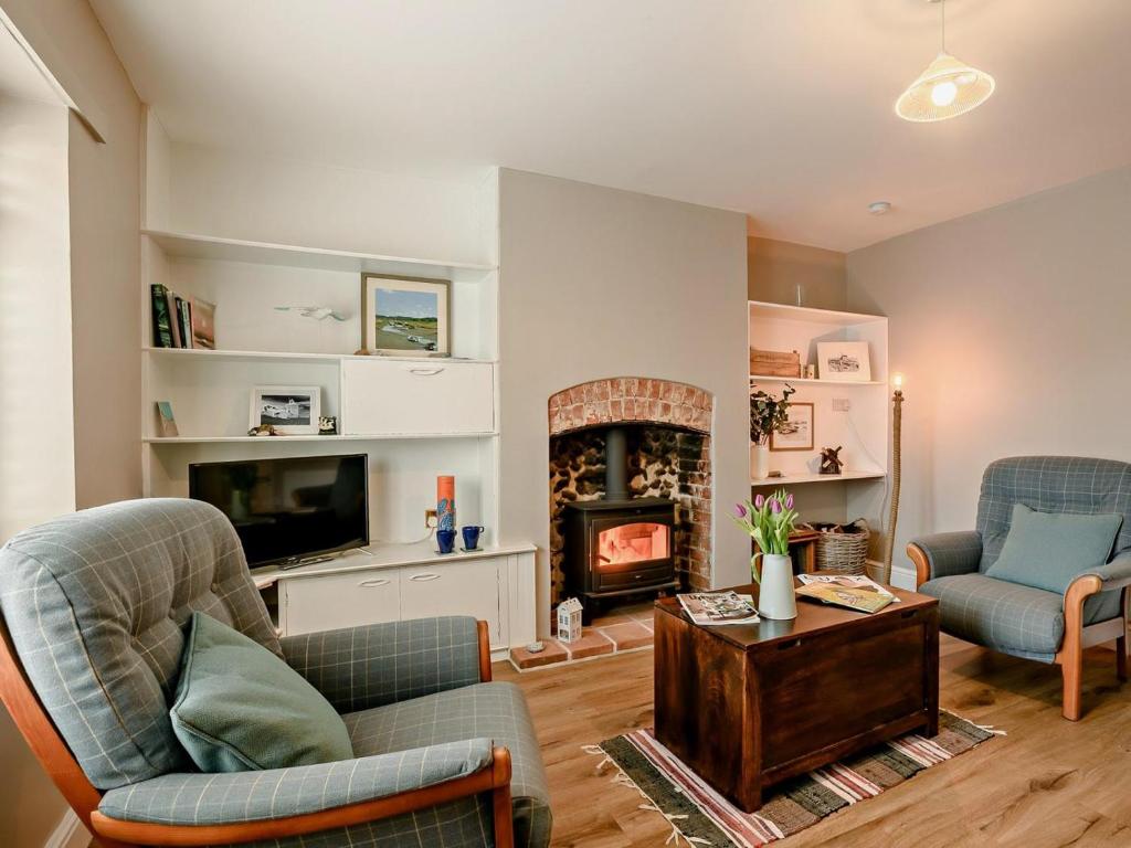 a living room with two chairs and a fireplace at 2 Bed in Melton Constable oc-91371 in Briston
