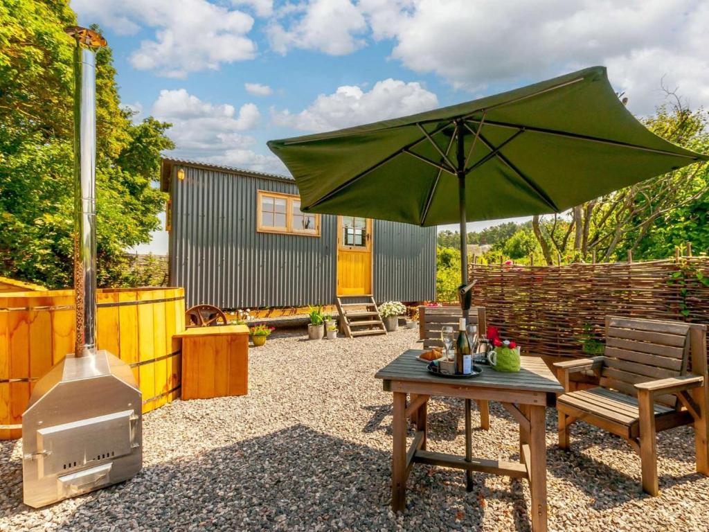 a patio with a table and an umbrella and a stove at 1 Bed in Canterbury oc-88795 in Chillenden