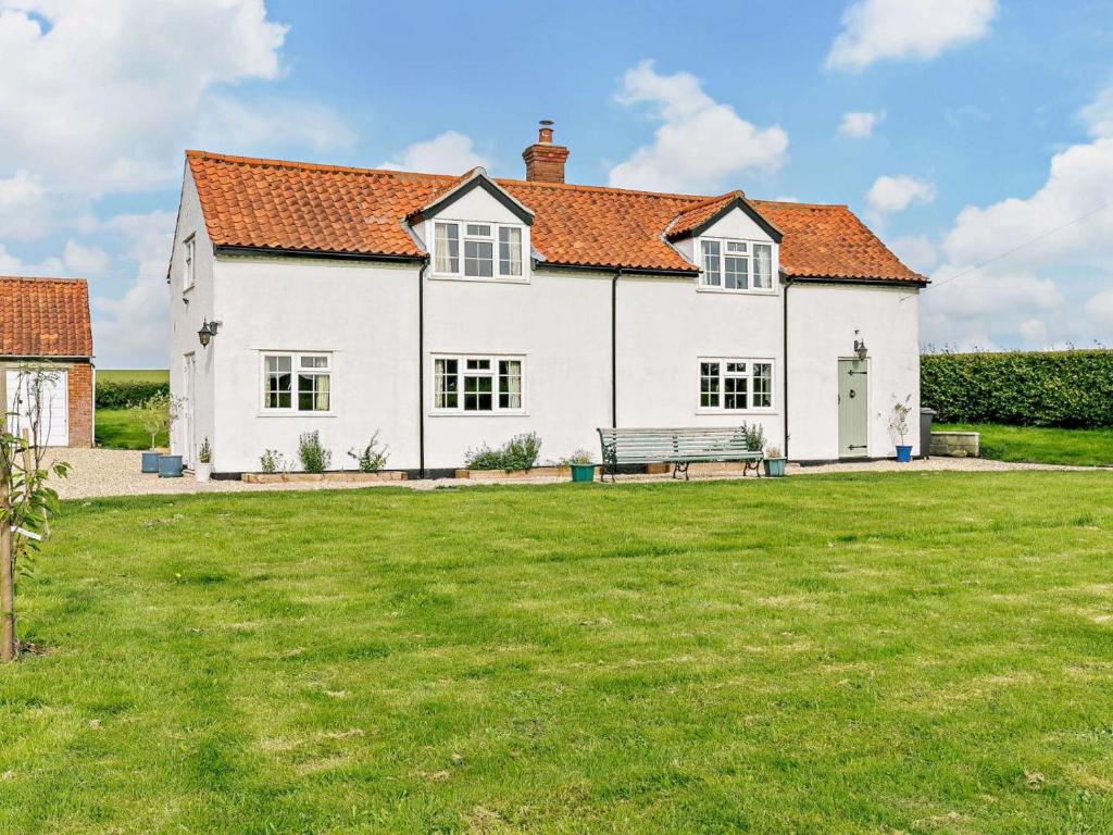 a white house with a bench in a yard at 3 Bed in Market Rasen oc-93253 in Ranby