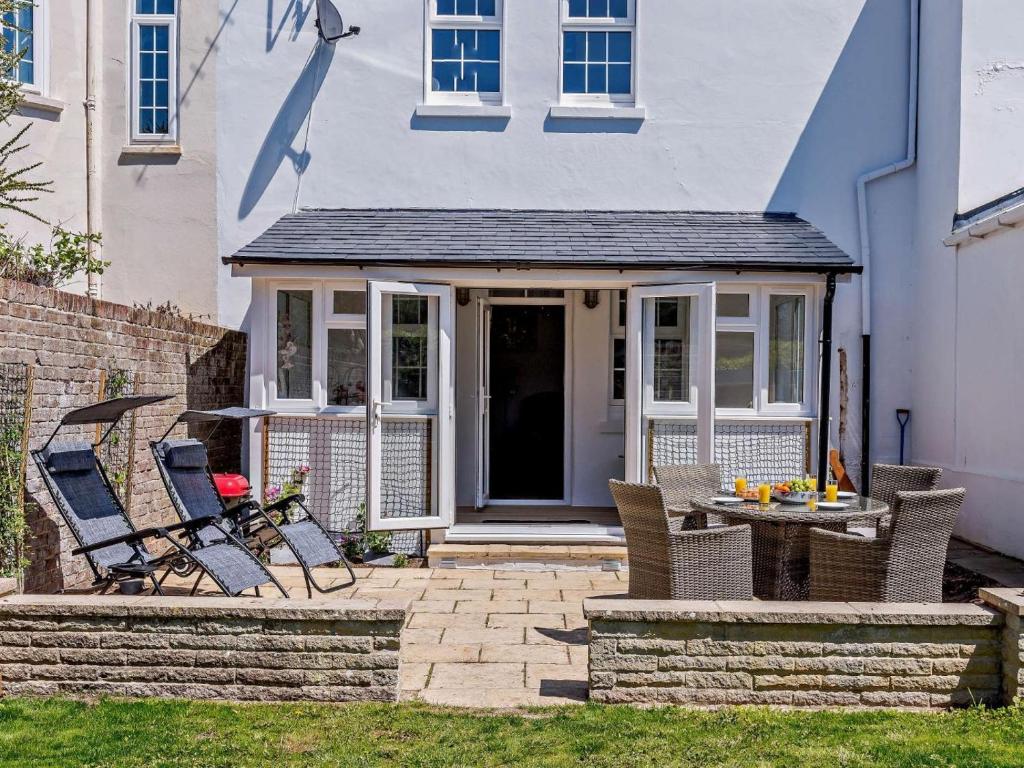a patio with chairs and a table in front of a house at 3 Bed in Bognor Regis oc-83115 in Bognor Regis
