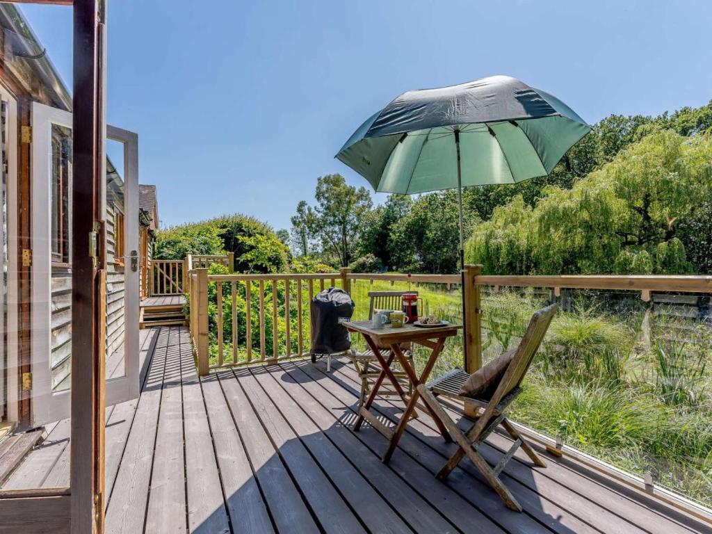 a patio with a table and an umbrella on a deck at 2 Bed in Uckfield oc-80504 in Framfield