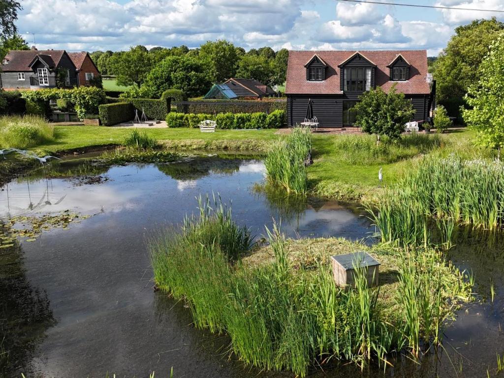 a house and a pond in front of a house at 1 Bed in Horsham oc-86961 in Rudgwick