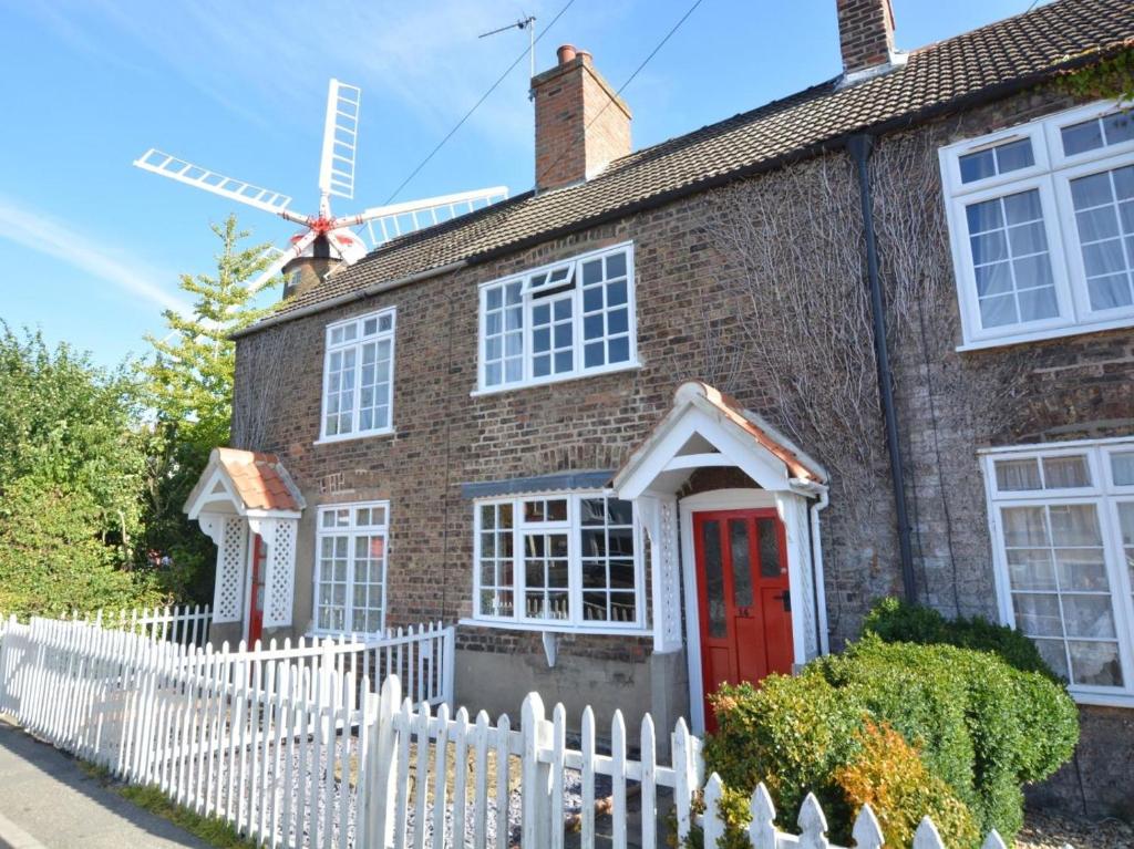 a brick house with a red door and a windmill at 2 Bed in Boston oc-90123 in Boston