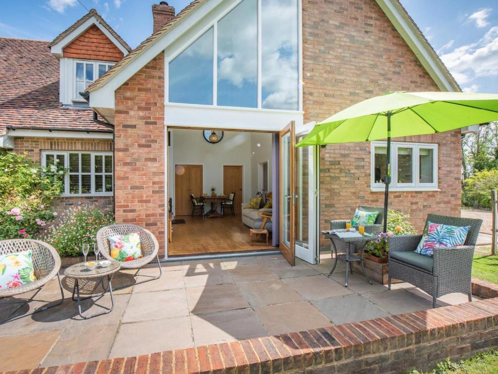 a patio with a green umbrella and chairs at 1 Bed in Etchingham oc-78940 in Hawkhurst