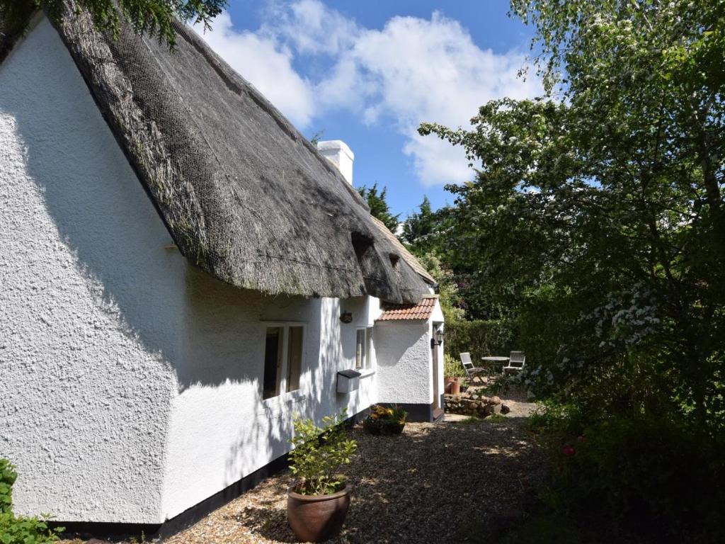 a white cottage with a thatched roof at 2 Bed in Bedford oc-62322 in Wyboston