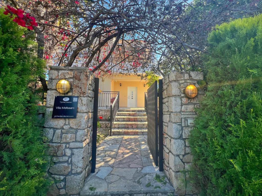 an entrance to a house with a stone wall and a gate at Villa Melissani in Karavomylos