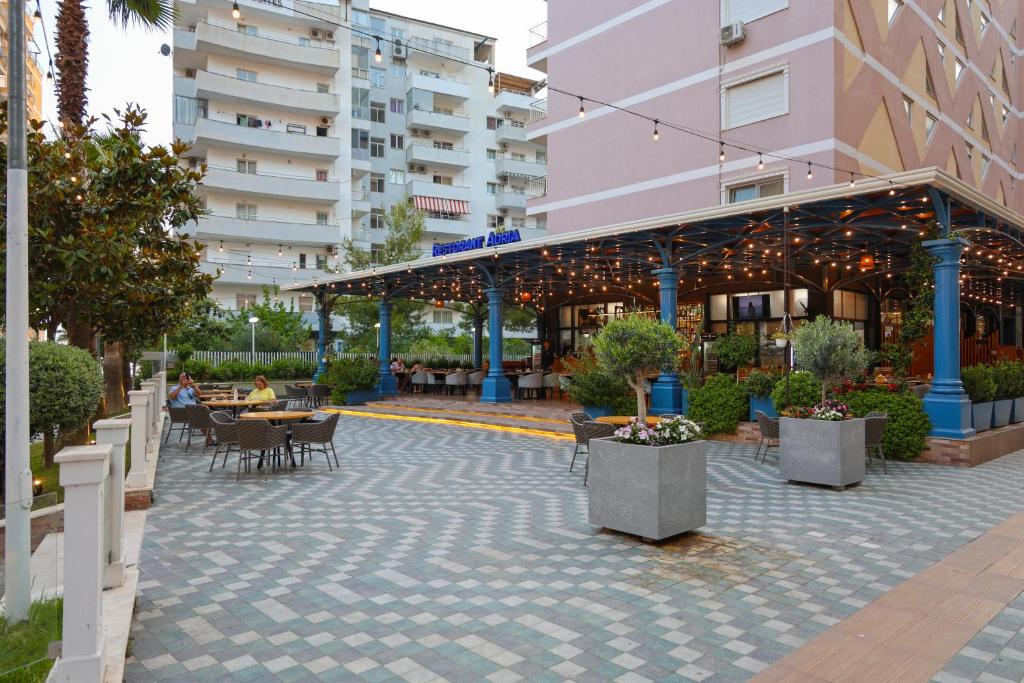 a patio in a building with people sitting at tables at Hotel Adria 2 Shengjin in Shëngjin