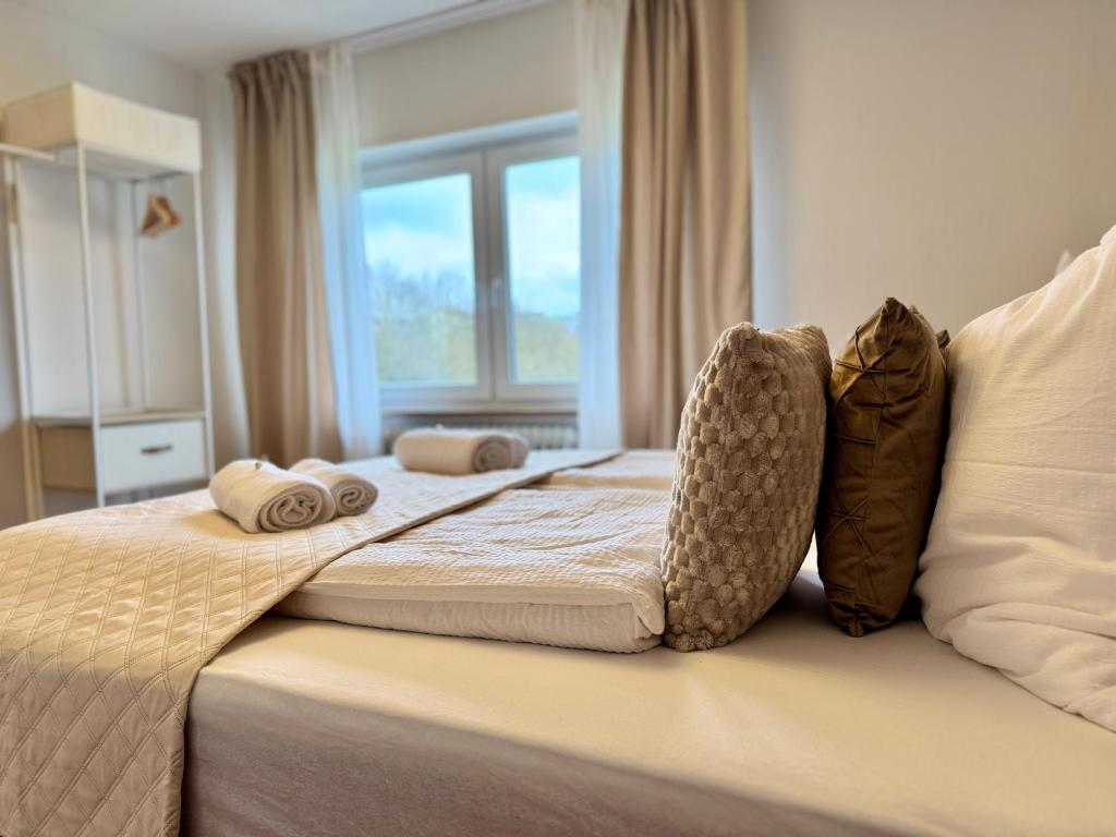 a bed with pillows on it with a window at FeWo Pelkmann - Die Grüne Oase - Ganzes Haus in Weikersheim