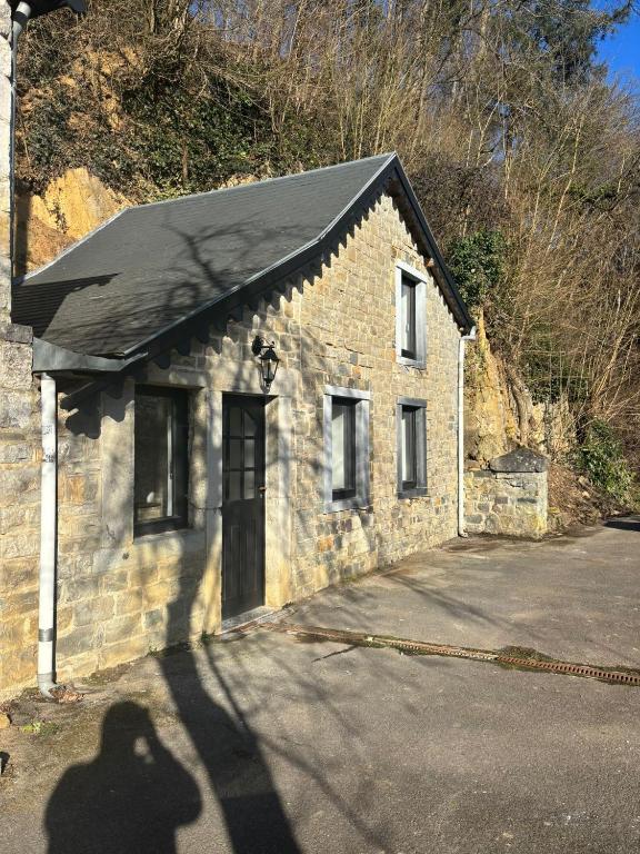 a building with a shadow of a person standing outside at Maison Aline in Hotton