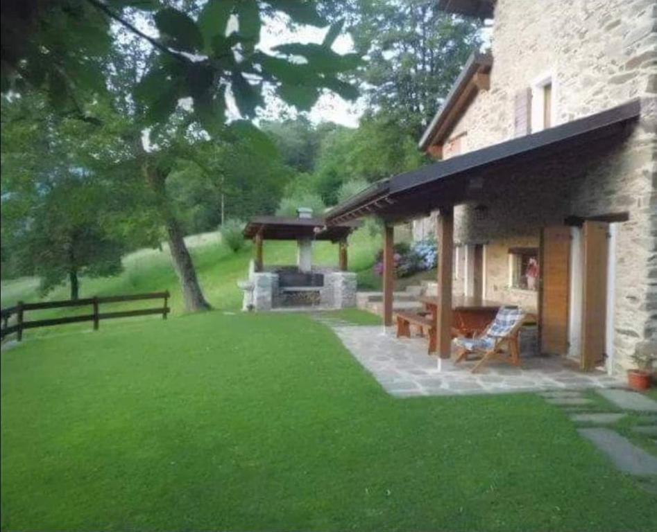 a backyard with a grill and a house at La Casetta di Cri Morbegno in Morbegno