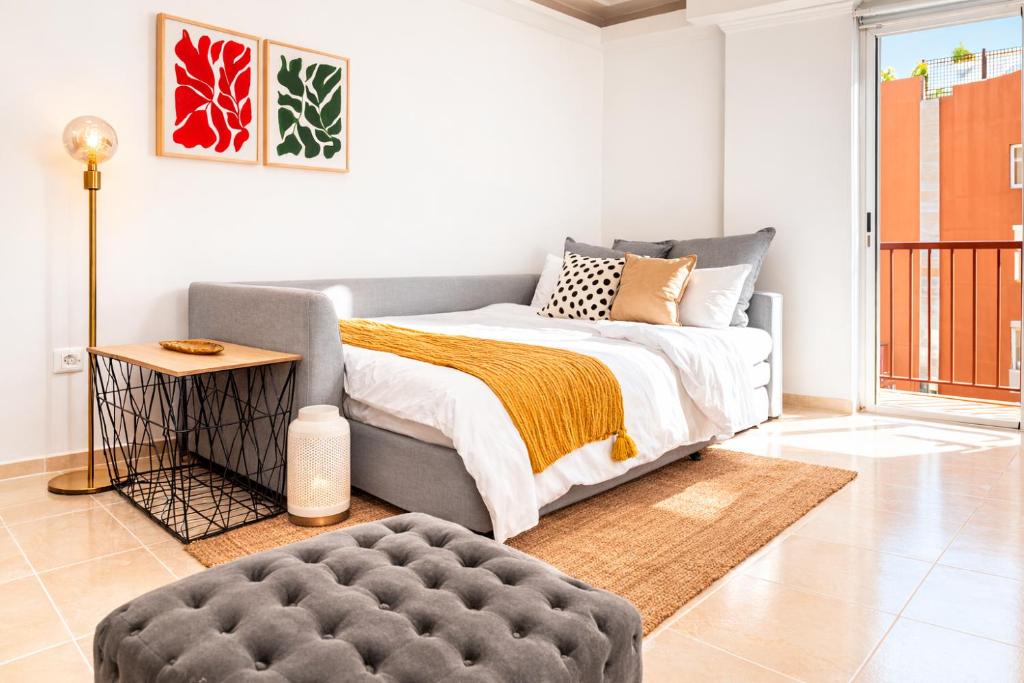 a bedroom with a bed and a ottoman at Profithome-Punta Larga in Candelaria