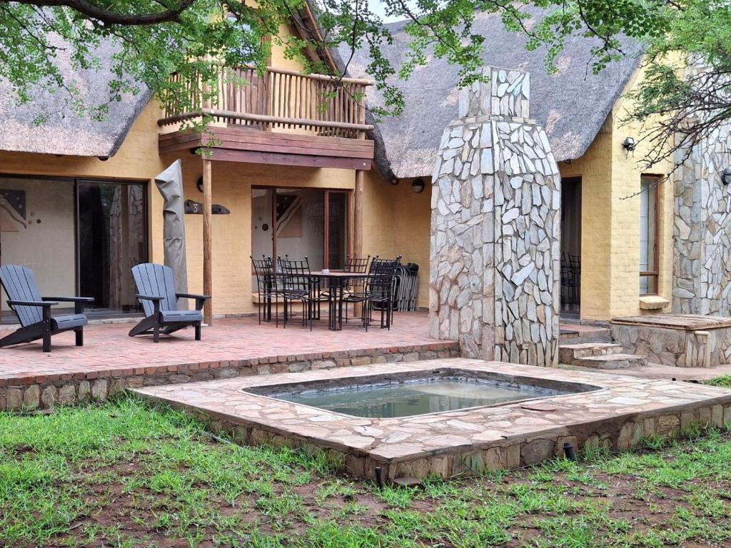 a patio with a pool and a table and chairs at Akasia - 333 in Hoedspruit