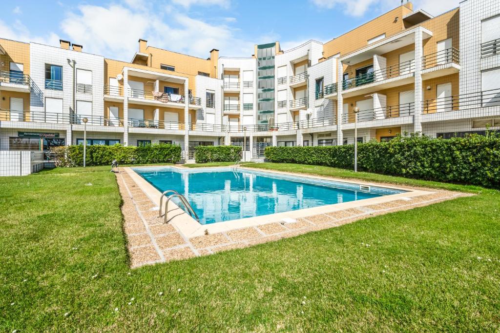 a swimming pool in a yard in front of a building at Houten Apartment Apulia in Apúlia