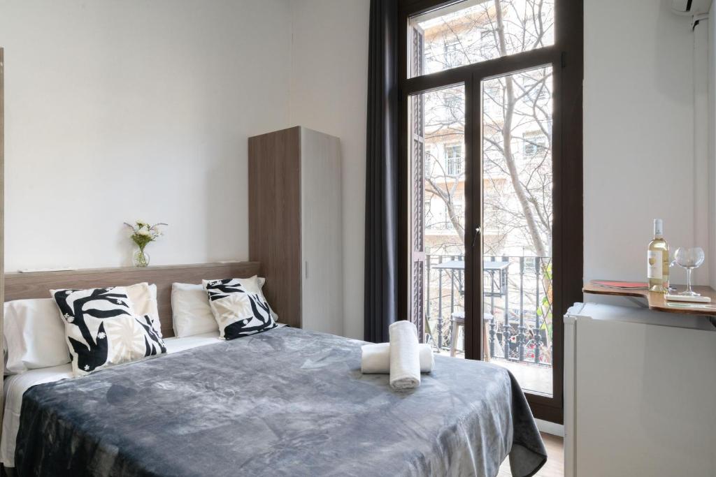 a bedroom with a bed and a large window at Hostal Sant Antoni in Barcelona