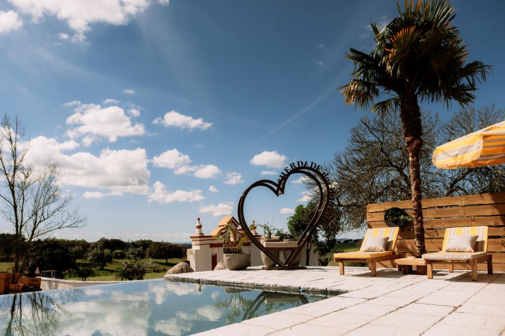 a heart shaped bench next to a swimming pool at Herdade dos Moreiros in Arronches