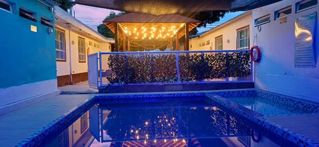 a swimming pool in front of a house at night at Hostal Casa del Palmar in Santa Marta