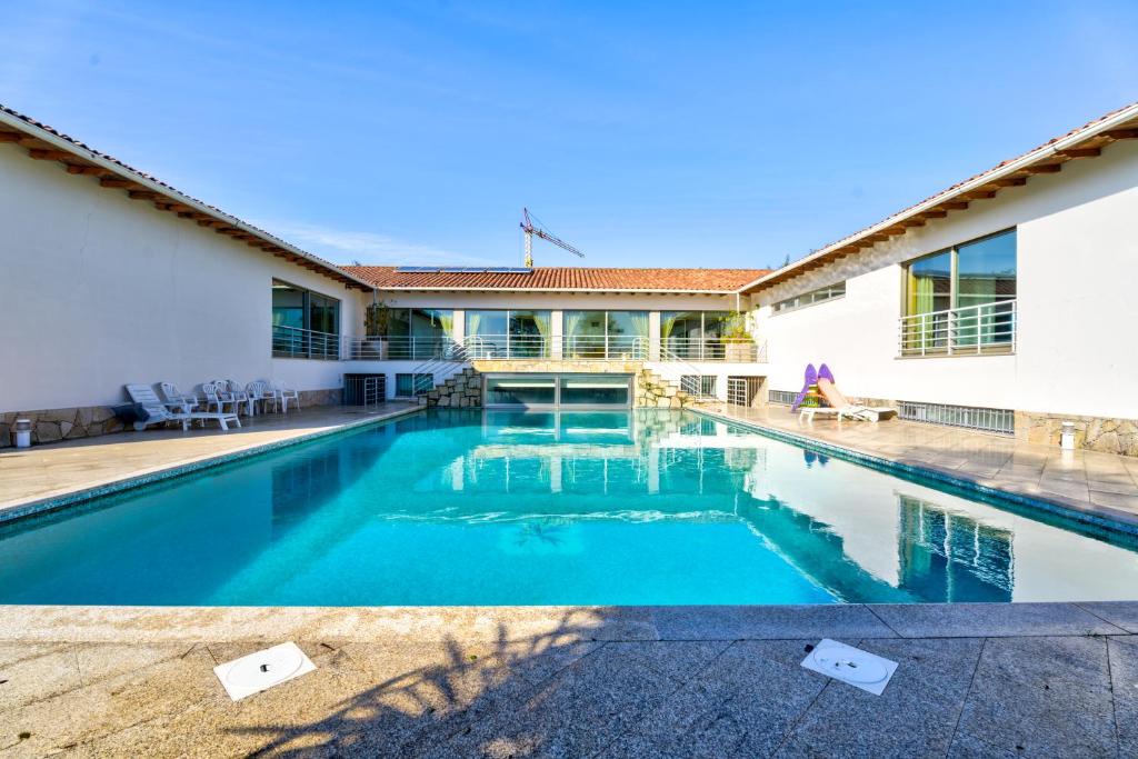 a swimming pool in front of a house at Lagos House in Braga