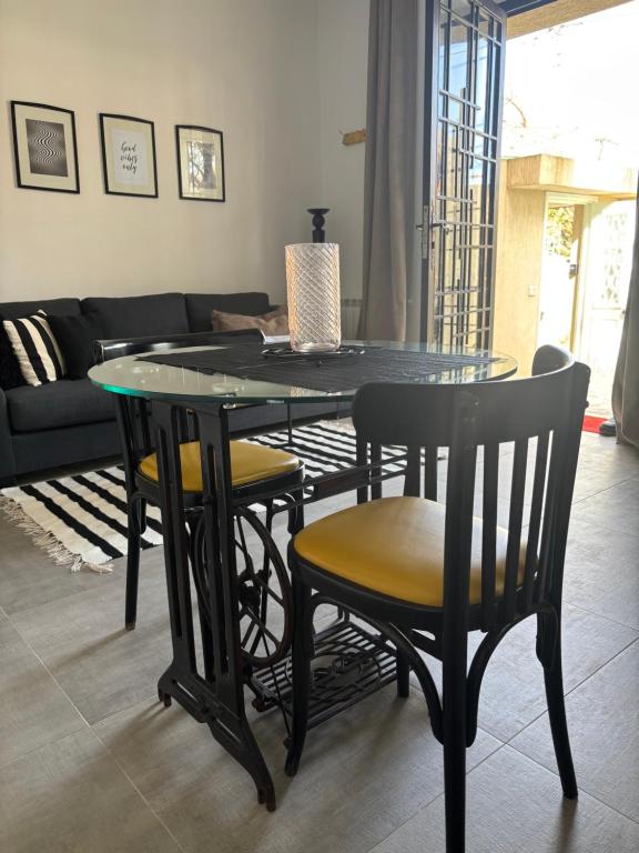 a dining room table and chairs in a living room at Work and Wave cosy studio at La Marsa in Douar el Hafey