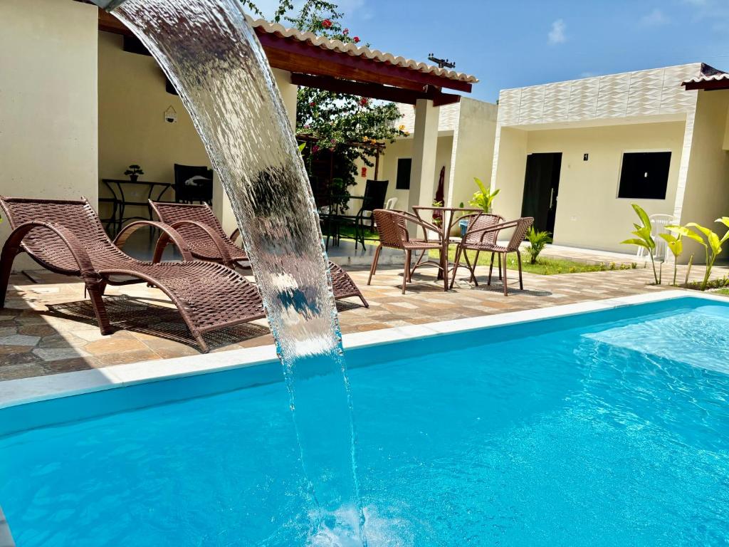 a swimming pool with a water fountain at Pousada Peromar in Maragogi
