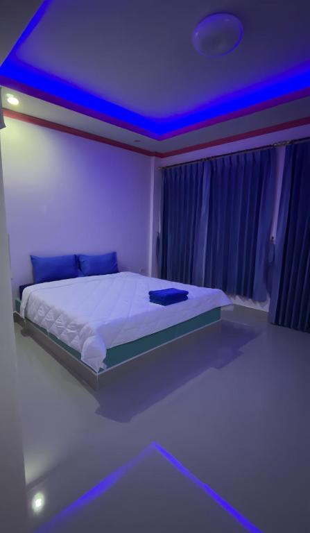 a bedroom with a bed with a blue lighting at Ying Fah Resort in Ban Na Sok