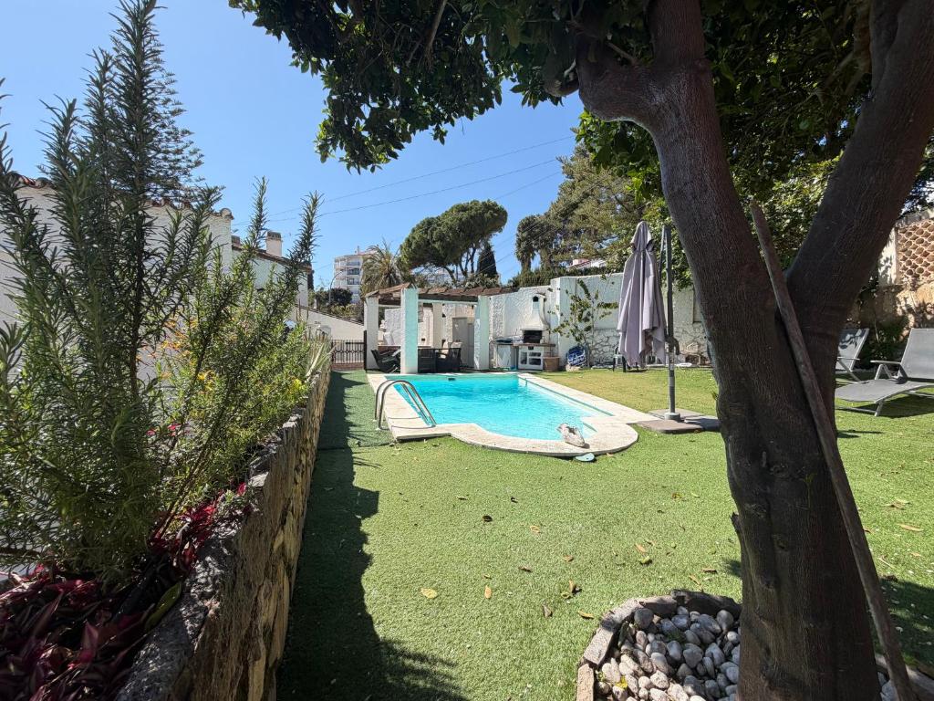 a pool in a yard with a person laying on a swing at Villa puerto marina beach in Benalmádena