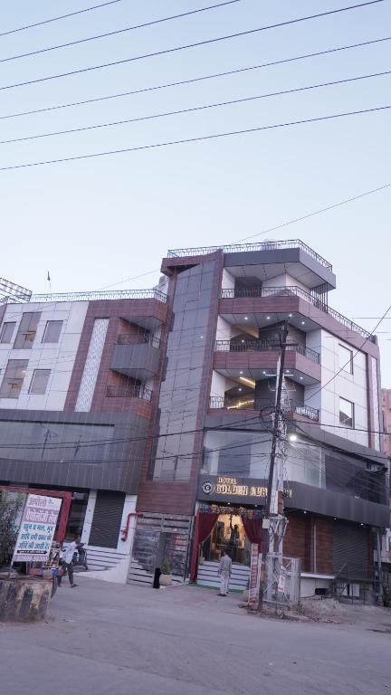 a large building with people standing outside of it at Hotel Golden Aura Inn in Gwalior