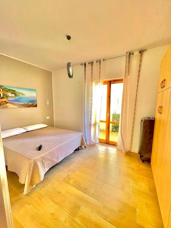a bedroom with a bed and a large window at Casa Vacanza Regina in Scalea