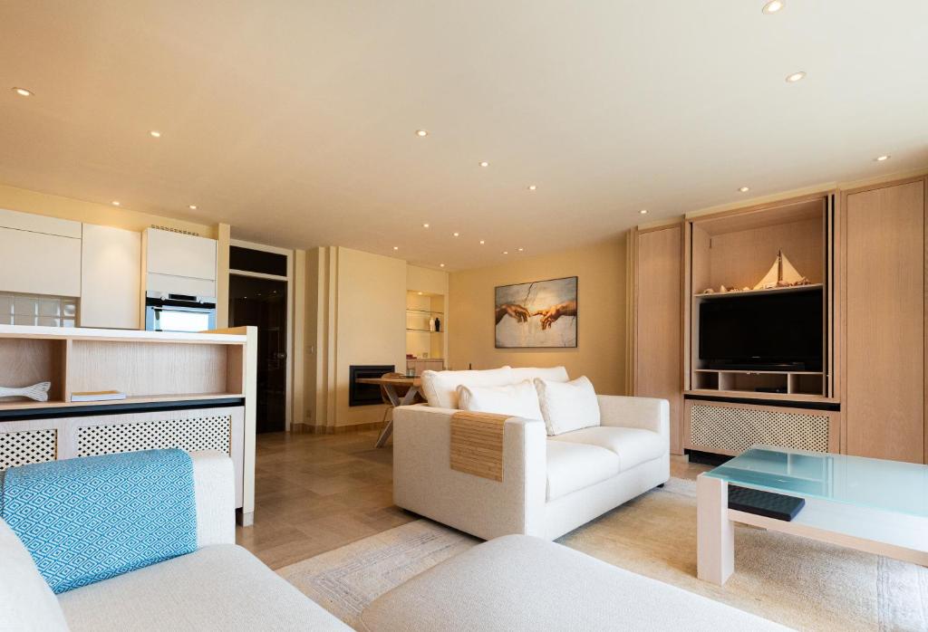 a living room with a white couch and a table at Villa Castelli 52 Groenendijk in Nieuwpoort