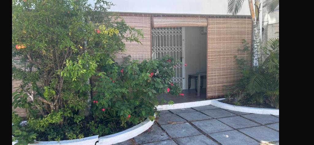a building with a door with a bush with red flowers at Aqua Aura 2 Bedroom Apartment Pereybere in Pereybere