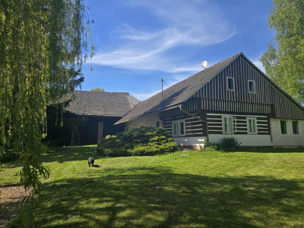 a black and white house with a dog in the yard at carpedieme in Horní Brusnice