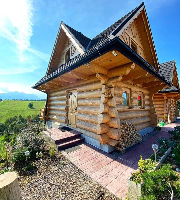 a log cabin with a porch and a deck at Domki Góralskie Dwa Misie in Bukowina Tatrzańska