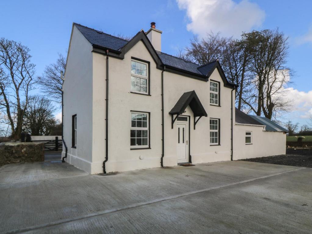 a white building with a black roof at Gate House in Llangefni