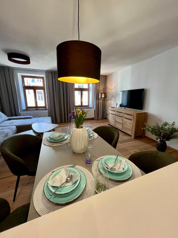 a living room with a table with plates on it at Core Apartments Jihlava in Jihlava