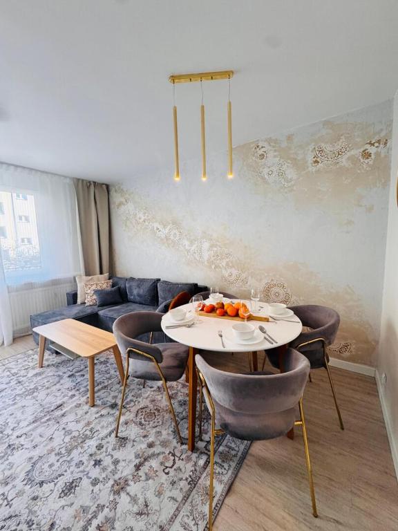 a living room with a couch and a table and chairs at ApartamentySnu, Apartament Nad Potokiem in Radom