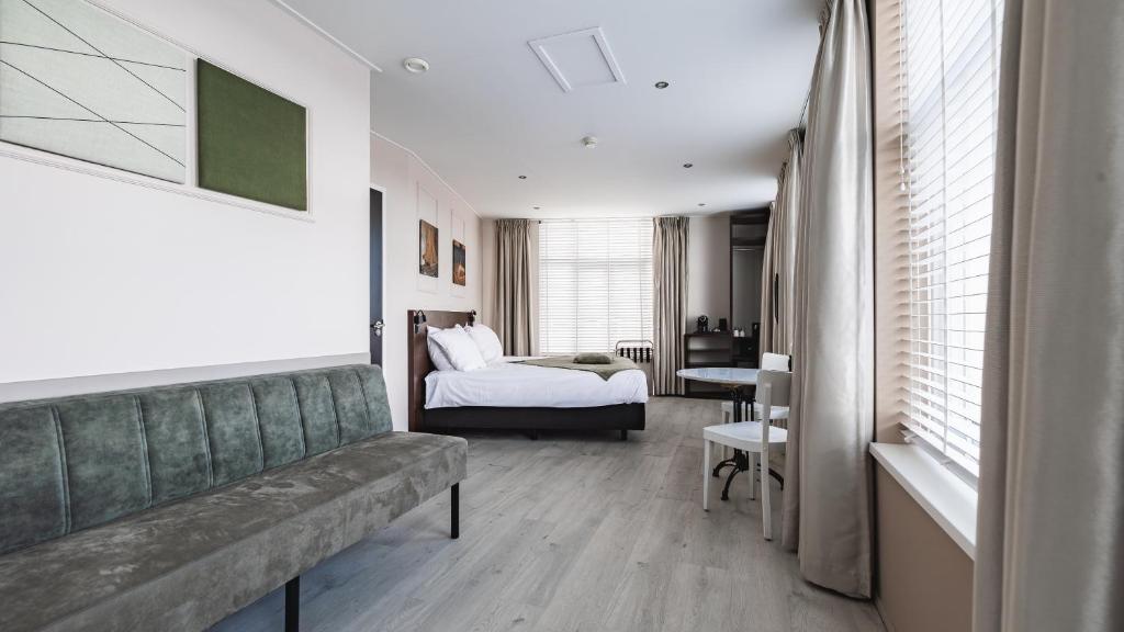 a room with a couch and a bed and a bedroom at Hotel Bella Ciao in Harderwijk