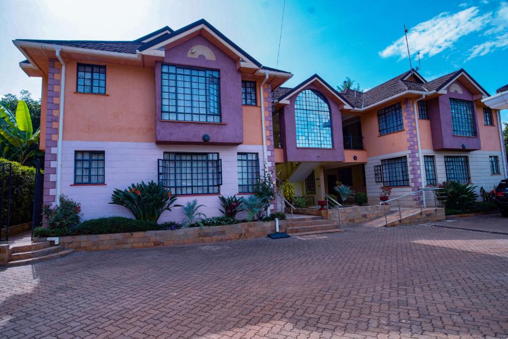 a house with a brick driveway in front of it at Davis Court in Nyeri
