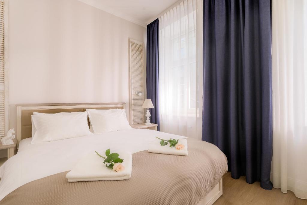 a bedroom with a white bed with two towels on it at Stabu Sēta Residence in Riga