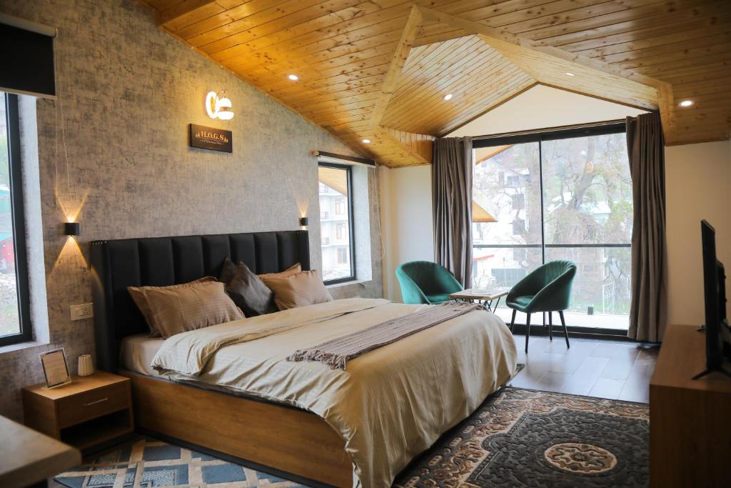 a bedroom with a large bed and a table and chairs at HOGS Panorama - Manali in Manāli