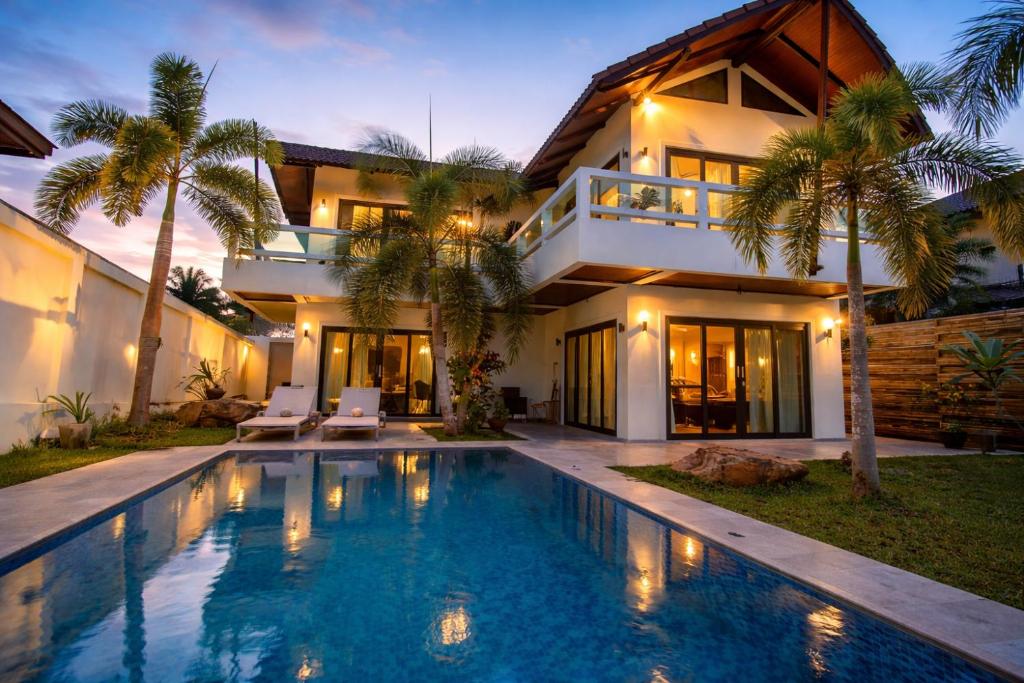 a house with a swimming pool in front of a house at Resona Pool Villa in Ao Nam Mao