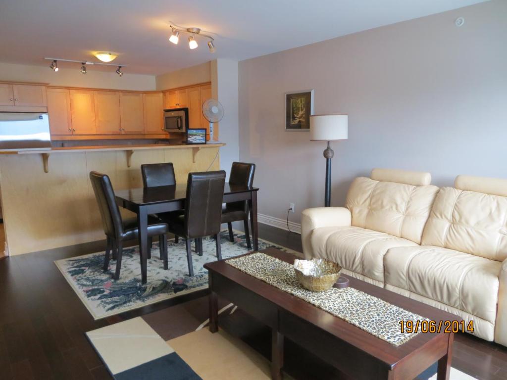 a living room with a couch and a table with chairs at Kaslo Bay Condominium in Kaslo
